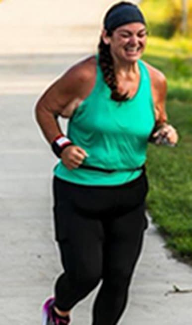 Chrissy running outdoors in a teal tank top